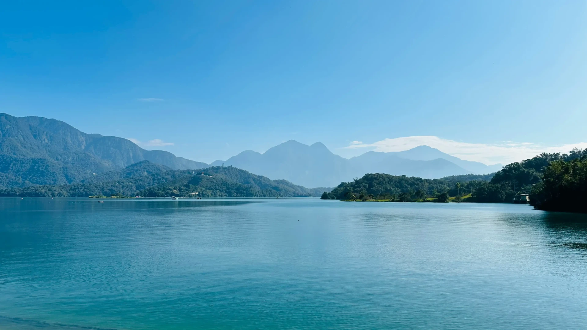 晴朗天氣下的日月潭湖景，平靜湖面與遠山稜線